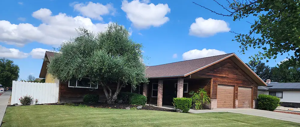Pretty home with blue sky and clouds in background. Home had new attic vents and insulation in Hanford, California