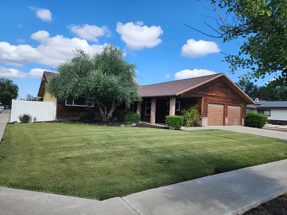 Pretty home with blue sky and clouds in background. Home had new attic vents and insulation in Hanford, California